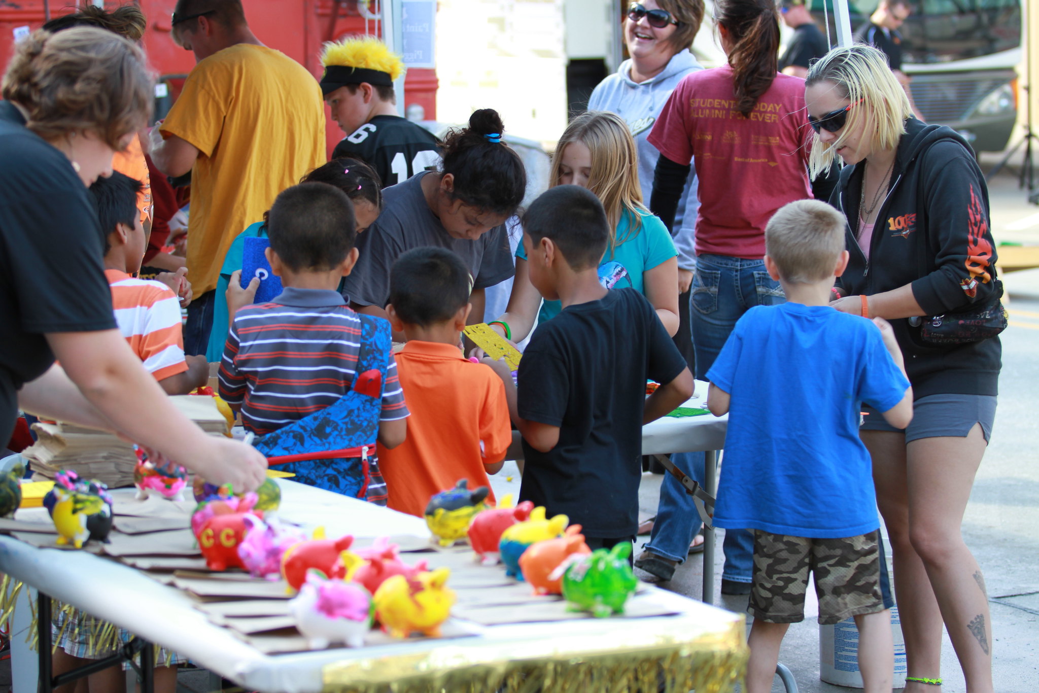 Women are helping a diverse group of kids to make crafts
